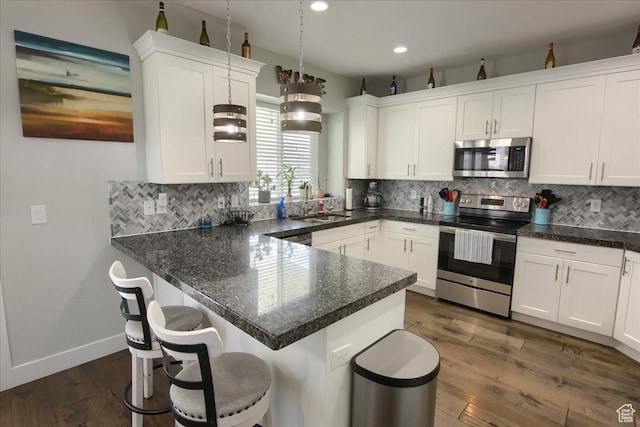 342 E Chiswick Ct, Stansbury Park, UT 84074 - kitchen featuring stainless steel appliances, white cabinetry, decorative backsplash, and recessed lighting