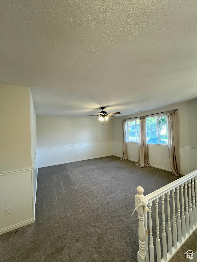 345 E 350 N, Salem, UT 84653 - spare room with a textured ceiling, dark carpet, ceiling fan, and a wainscoted wall