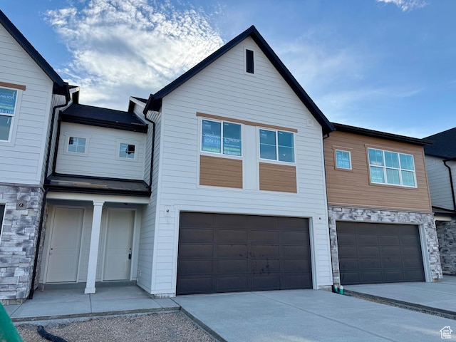 2727 N 2775 W Unit 122, Plain City, UT 84404 - view of property featuring stone siding, an attached garage, and driveway