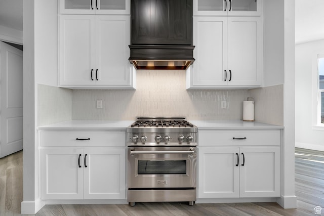 827 W 800 N, American Fork, UT 84003 - kitchen featuring high end stainless steel range oven, custom range hood, light countertops, white cabinetry, and backsplash