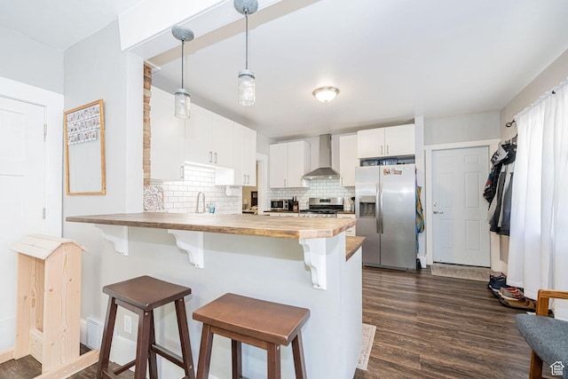 141 W 400 N, Logan, UT 84321 - kitchen featuring appliances with stainless steel finishes, wall chimney range hood, a peninsula, and dark wood-type flooring