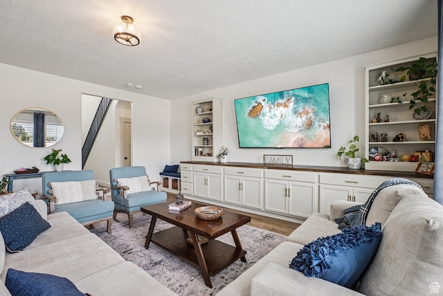2577 W Garden Creek Way Unit 106, West Jordan, UT 84088 - living area featuring built in features, light wood finished floors, and a textured ceiling