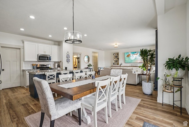 2577 W Garden Creek Way Unit 106, West Jordan, UT 84088 - dining space with light wood-type flooring, recessed lighting, and a chandelier
