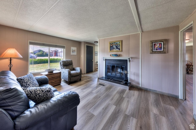 1281 Holyoak Ln E, Moab, UT 84532 - living area featuring wood finished floors, a glass covered fireplace, and a textured ceiling