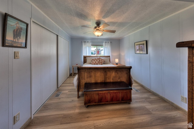 1281 Holyoak Ln E, Moab, UT 84532 - bedroom with a decorative wall, light wood-style flooring, a closet, and a ceiling fan