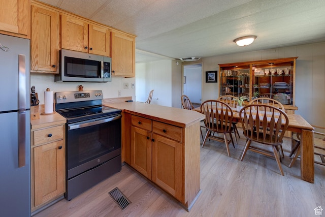 1281 Holyoak Ln E, Moab, UT 84532 - kitchen featuring stainless steel appliances, a peninsula, light wood-type flooring, and light countertops