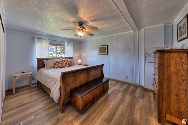 1281 Holyoak Ln E, Moab, UT 84532 - bedroom with light wood-type flooring, a ceiling fan, crown molding, and a textured ceiling
