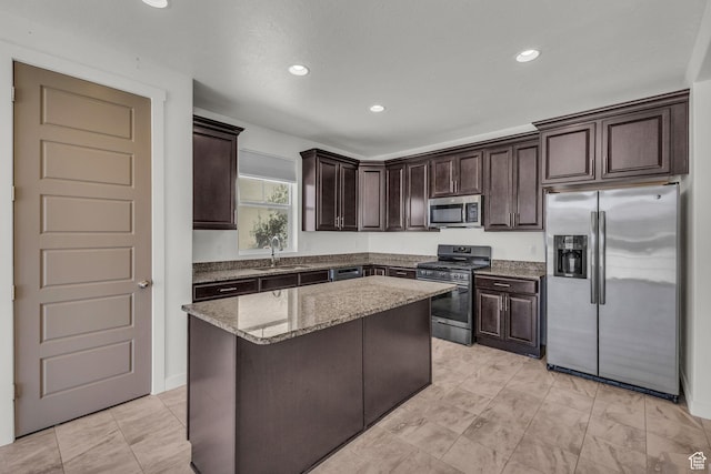 773 W Mulberry St, Stansbury Park, UT 84074 - kitchen featuring appliances with stainless steel finishes, dark brown cabinets, light stone counters, a kitchen island, and recessed lighting