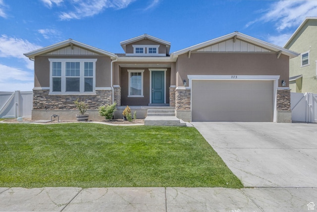 773 W Mulberry St, Stansbury Park, UT 84074 - view of front of house featuring stone siding, a gate, an attached garage, and stucco siding