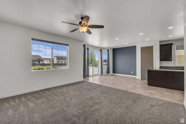 773 W Mulberry St, Stansbury Park, UT 84074 - unfurnished living room with ceiling fan, light tile patterned flooring, recessed lighting, light carpet, and a textured ceiling