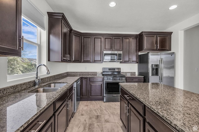 773 W Mulberry St, Stansbury Park, UT 84074 - kitchen with stainless steel appliances, dark stone counters, dark brown cabinets, light marble finish floors, and recessed lighting
