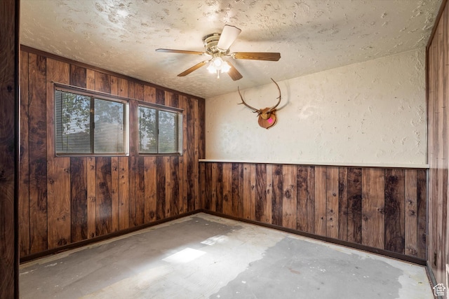 5374 S 5700 W, Hooper, UT 84315 - unfurnished room with wooden walls, ceiling fan, concrete flooring, and a textured ceiling