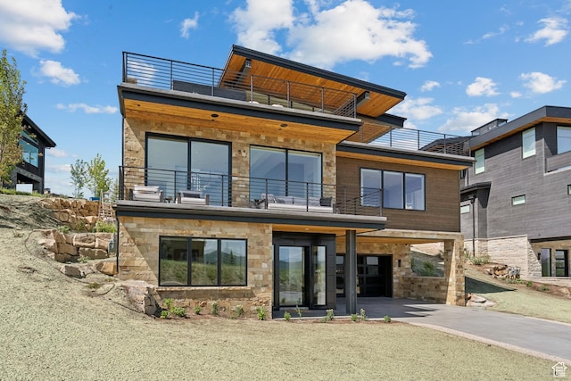 1404 W Ursa Way, Heber City, UT 84032 - back of house with a balcony, stone siding, a carport, and driveway