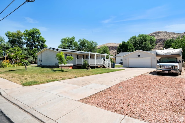 10 E 200 N, La Verkin, UT 84745 - view of front of property with a porch, a mountain view, a front yard, concrete driveway, and solar panels