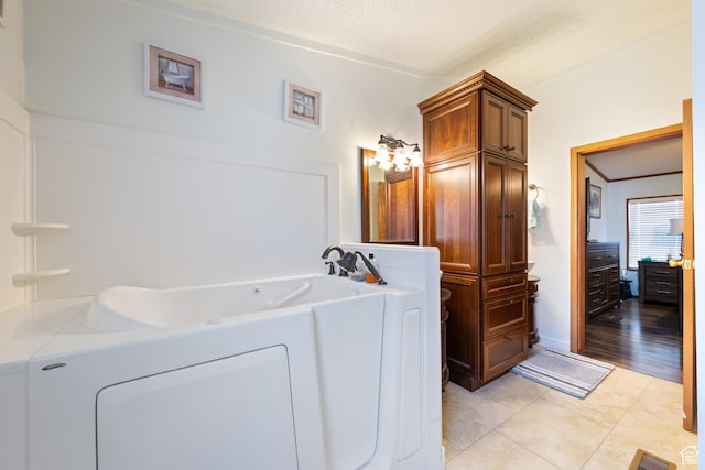 10 E 200 N, La Verkin, UT 84745 - bathroom with a bath, washing machine and clothes dryer, a textured ceiling, and tile patterned flooring