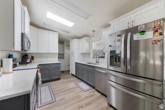 10 E 200 N, La Verkin, UT 84745 - kitchen with stainless steel appliances, light wood-style floors, a textured ceiling, and white cabinets