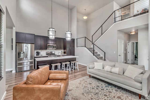 10363 S Silver Mine Rd, South Jordan, UT 84009 - living room with a towering ceiling, light wood-type flooring, and stairs