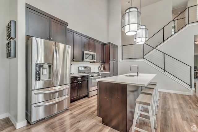 10363 S Silver Mine Rd, South Jordan, UT 84009 - kitchen featuring stainless steel appliances, light countertops, light wood-style floors, and a high ceiling