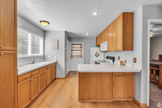 1624 Pine Cone Cir, Coalville, UT 84017 - kitchen featuring white appliances, a peninsula, light countertops, light wood-type flooring, and recessed lighting