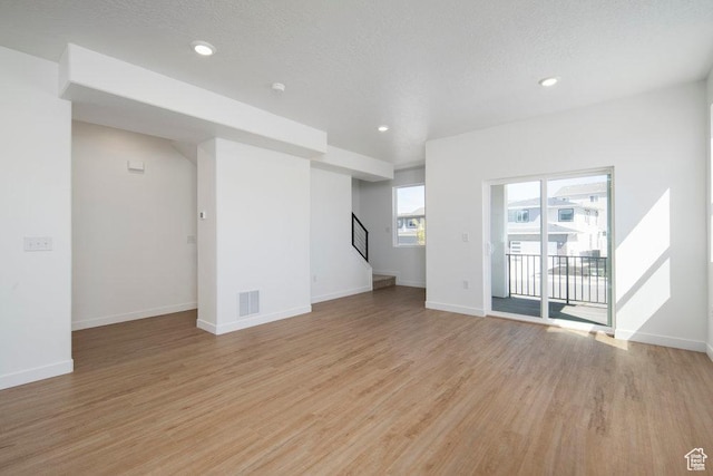 924 W Coalburn Way Unit 8-26, Murray, UT 84123 - unfurnished living room with light wood-style flooring, stairway, and recessed lighting