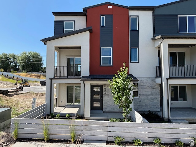924 W Coalburn Way Unit 8-26, Murray, UT 84123 - modern home with a balcony, a fenced front yard, stucco siding, and stone siding
