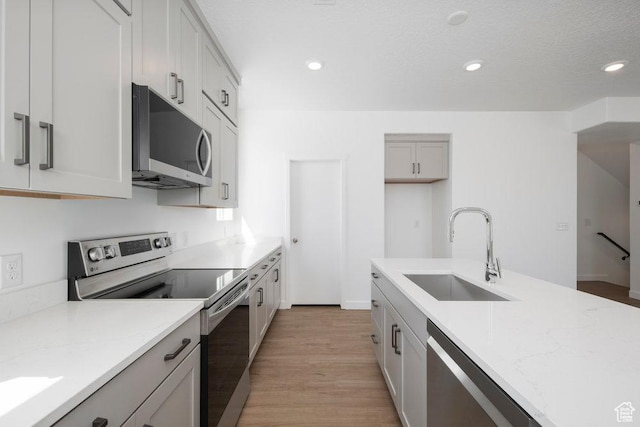 924 W Coalburn Way Unit 8-26, Murray, UT 84123 - kitchen featuring stainless steel appliances, light wood finished floors, light stone countertops, and recessed lighting