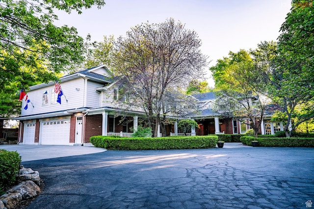 1734 E Spring Ln, Holladay, UT 84117 - view of front of property featuring brick siding, a porch, a garage, and driveway