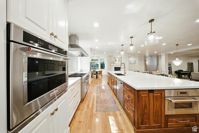 1734 E Spring Ln, Holladay, UT 84117 - kitchen with wall chimney range hood, appliances with stainless steel finishes, light wood-type flooring, brown cabinetry, and white cabinetry
