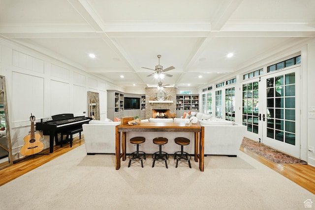1734 E Spring Ln, Holladay, UT 84117 - kitchen featuring coffered ceiling, a breakfast bar, light wood-style flooring, ceiling fan, and a fireplace
