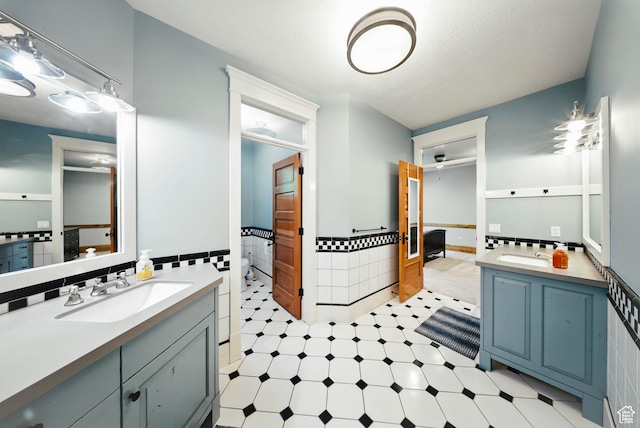 1734 E Spring Ln, Holladay, UT 84117 - full bathroom with vanity, tile patterned floors, tile walls, and a wainscoted wall