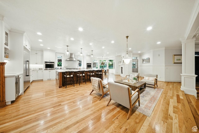 1734 E Spring Ln, Holladay, UT 84117 - living area featuring decorative columns, crown molding, light wood-type flooring, recessed lighting, and a wainscoted wall
