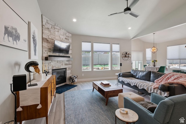 507 W 2030 N, Tooele, UT 84074 - living room with ceiling fan, light wood finished floors, healthy amount of natural light, a stone fireplace, and vaulted ceiling