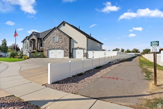 4987 S 5400 W, Hooper, UT 84315 - view of side of property with stone siding, a garage, concrete driveway, and stucco siding