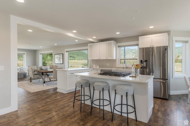 266 Old Ranch Rd W, Park City, UT 84098 - kitchen featuring appliances with stainless steel finishes, a center island, white cabinetry, dark wood finished floors, and a breakfast bar area