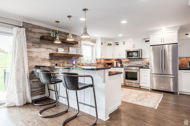 983 Mountain Willow Ln, Park City, UT 84098 - kitchen featuring stainless steel appliances, dark countertops, a kitchen bar, dark wood-type flooring, and recessed lighting
