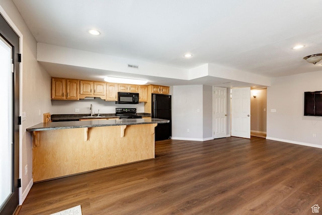 983 Mountain Willow Ln, Park City, UT 84098 - kitchen featuring black appliances, a breakfast bar, recessed lighting, a peninsula, and dark wood-style flooring