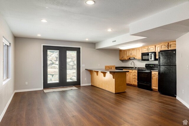 983 Mountain Willow Ln, Park City, UT 84098 - kitchen with black appliances, a kitchen breakfast bar, a peninsula, dark wood-style flooring, and recessed lighting