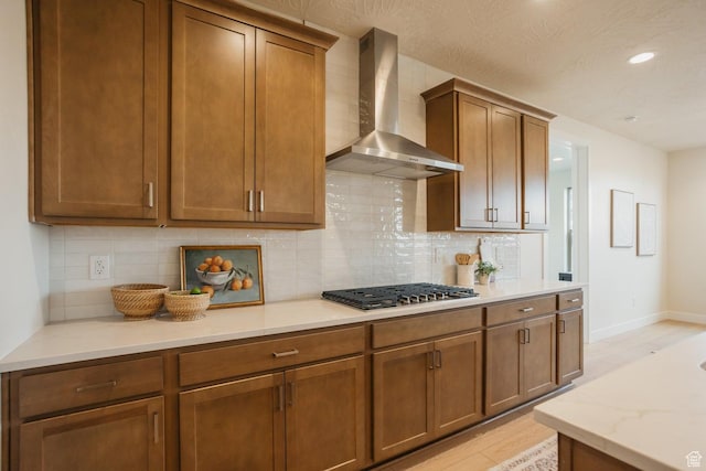 46 Rosalia Rdg, St George, UT 84770 - kitchen featuring wall chimney exhaust hood, stainless steel gas stovetop, light wood-style floors, tasteful backsplash, and recessed lighting