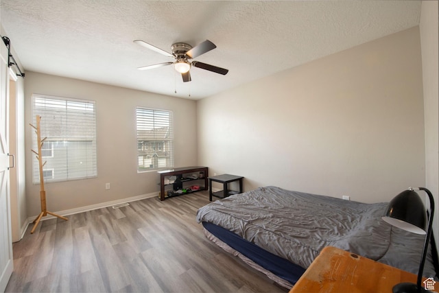3408 S Carrick Dr W, South Salt Lake, UT 84115 - bedroom featuring light wood-style flooring, a textured ceiling, and a ceiling fan