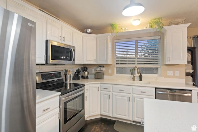 969 S Cove Rd, Saratoga Springs, UT 84045 - kitchen featuring stainless steel appliances, white cabinets, dark wood-type flooring, light countertops, and backsplash