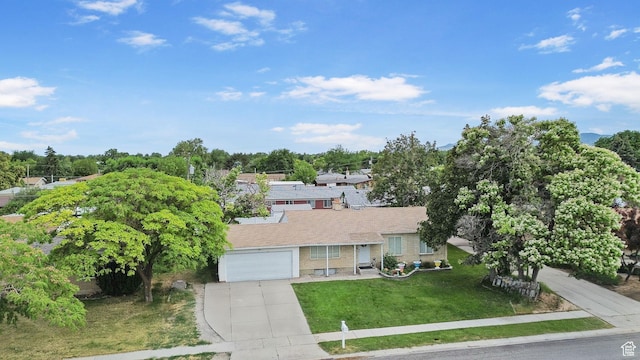 4895 W Pavant Ave, West Valley City, UT 84120 - view of front facade with driveway, a front yard, brick siding, a garage, and view of scattered trees
