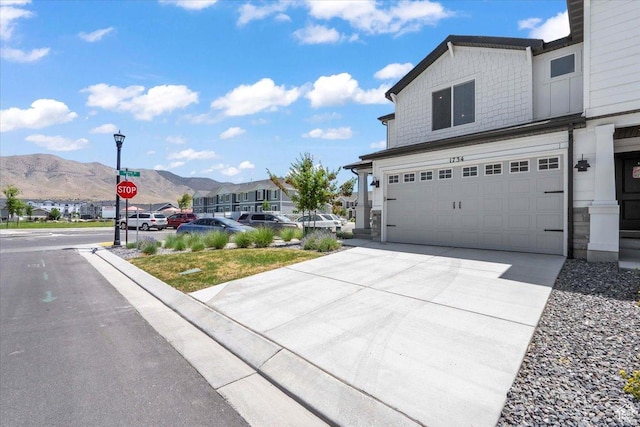 1734 E Muss Dr, Eagle Mountain, UT 84005 - view of side of home featuring a mountain view, driveway, stone siding, a residential view, and a garage