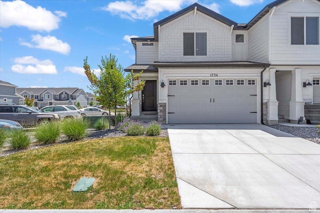1734 E Muss Dr, Eagle Mountain, UT 84005 - view of front facade with driveway, a garage, stone siding, and a front lawn