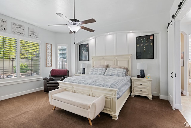 6923 W Long Ridge Dr S, Herriman, UT 84096 - bedroom with dark colored carpet, a barn door, arched walkways, and ceiling fan
