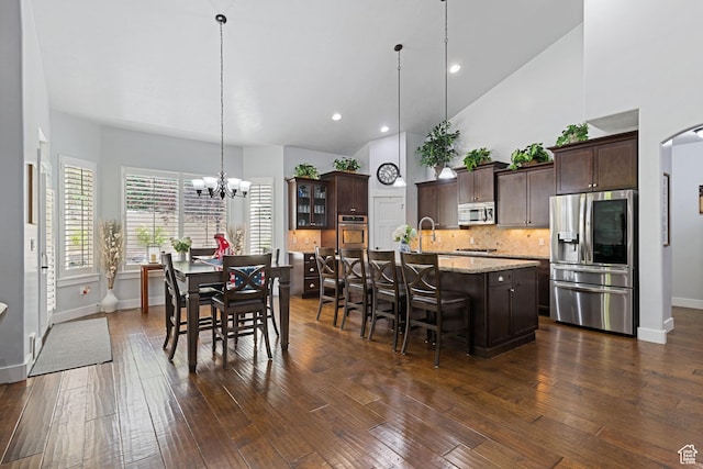 6923 W Long Ridge Dr S, Herriman, UT 84096 - dining room with a chandelier, dark wood finished floors, high vaulted ceiling, recessed lighting, and arched walkways