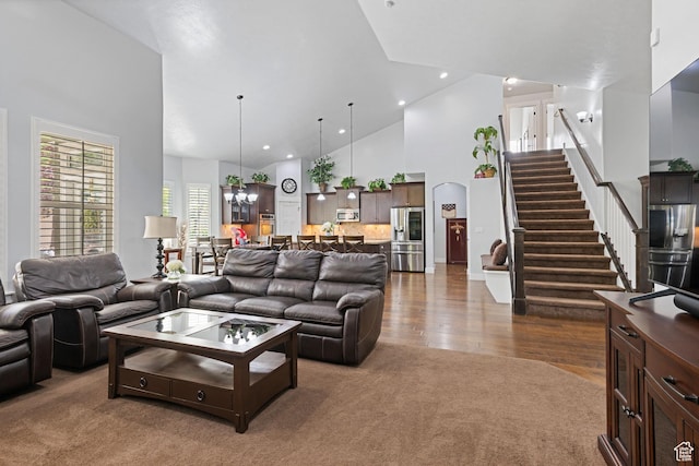 6923 W Long Ridge Dr S, Herriman, UT 84096 - living area featuring high vaulted ceiling, dark carpet, stairs, dark wood-style floors, and a chandelier