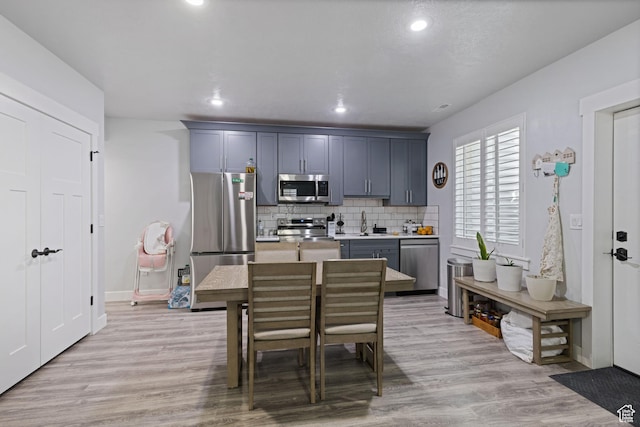 6923 W Long Ridge Dr S, Herriman, UT 84096 - kitchen with appliances with stainless steel finishes, decorative backsplash, light countertops, light wood-style flooring, and recessed lighting