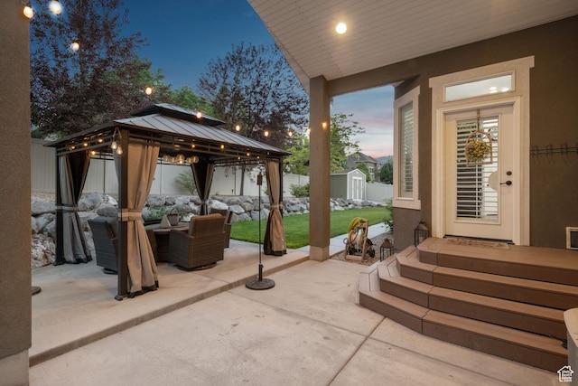 6923 W Long Ridge Dr S, Herriman, UT 84096 - patio terrace at dusk with outdoor lounge area, a patio, a storage unit, a fenced backyard, and a gazebo