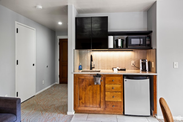 212 100 W 200 S Unit 212, Moab, UT 84532 - kitchen featuring fridge, black microwave, backsplash, brown cabinets, and light stone countertops