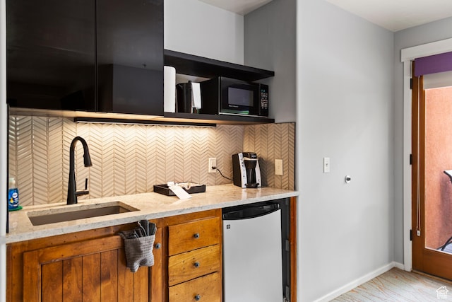 212 100 W 200 S Unit 212, Moab, UT 84532 - kitchen with refrigerator, brown cabinetry, light stone countertops, black microwave, and backsplash
